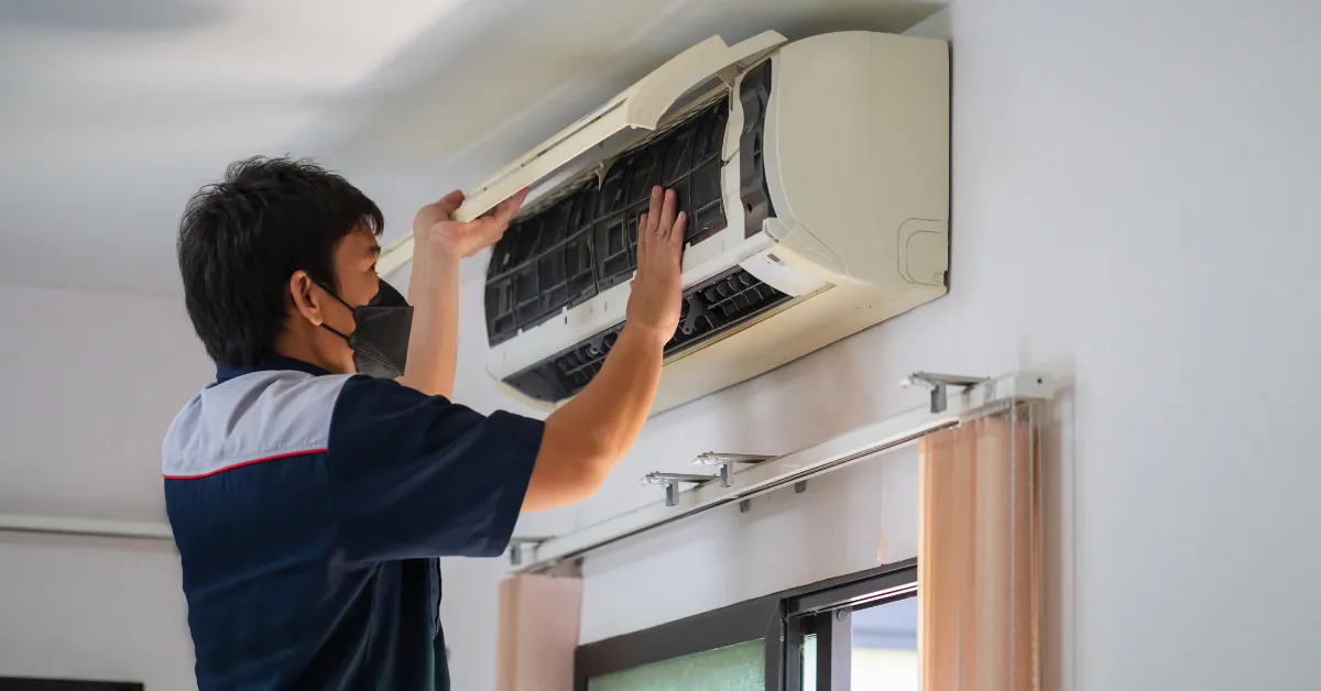 Rapid Response team member installing a wall-mounted air conditioning unit with a power drill inside a home in Fort Myers