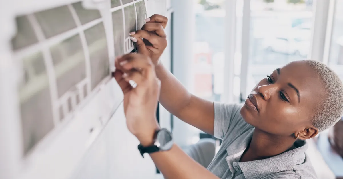 A technician is carefully adjusting the air conditioner filter to improve airflow and overall cooling performance