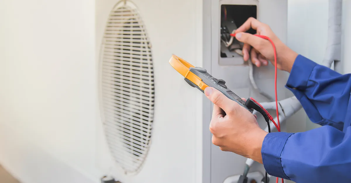 A technician using a multimeter to test and diagnose an outdoor air conditioning unit 