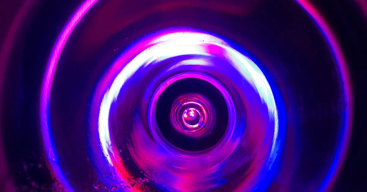 Vivid purple and blue UV light glowing inside a circular air purification chamber, creating a radiant halo effect
