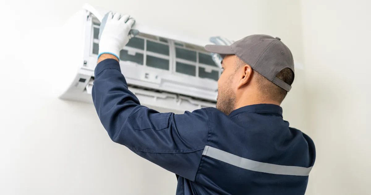 Specialist performing indoor unit cleaning and filter maintenance for efficient air cooling