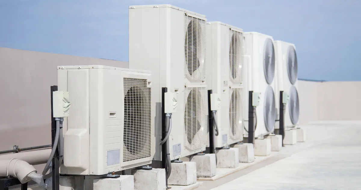 Row of rooftop HVAC condenser units installed on mounts