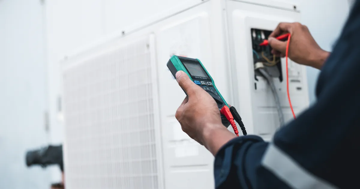HVAC service specialist performing diagnostic testing on outdoor unit circuitry using a digital multimeter