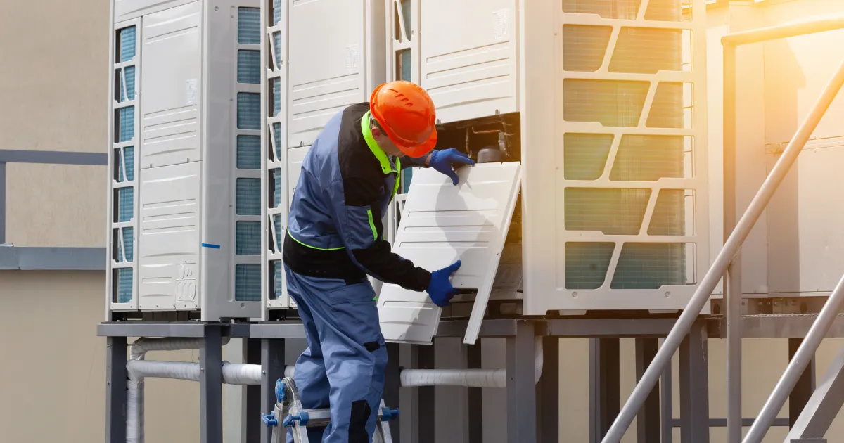 A Rapid Response Team technician is inspecting a rooftop commercial condenser unit panel