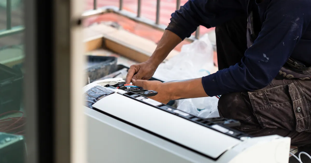 Rapid Response technician adjusting internal components on a split AC unit