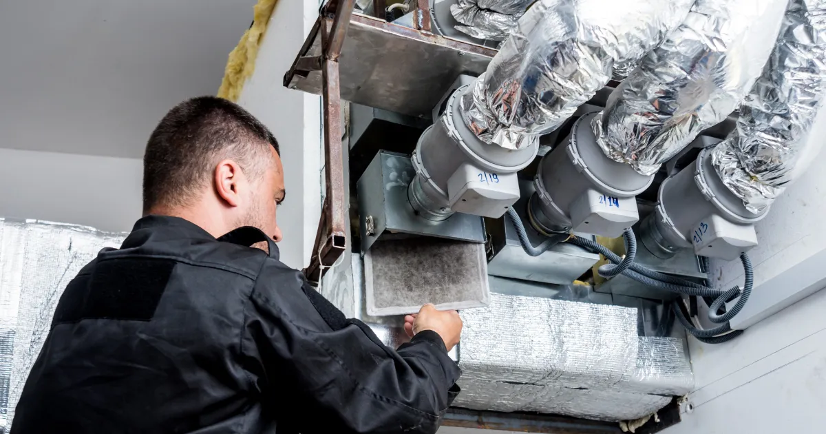 HVAC ventilation system maintenance with filter removal and insulated air ducts visible
