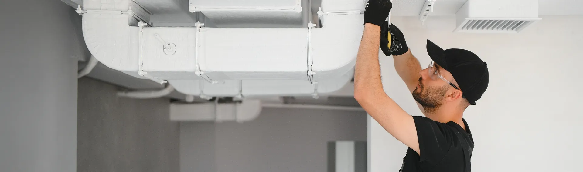 Rapid Response team member securing an outdoor AC condenser unit to the wall during installation service